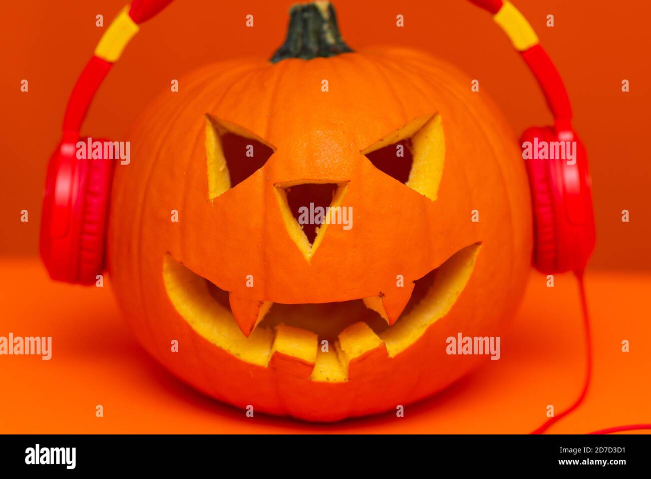 Happy Halloween decorazioni festival e musica concetto background.Mix varietà e zucca ascolto radio da cuffie su sfondo arancione. Foto Stock