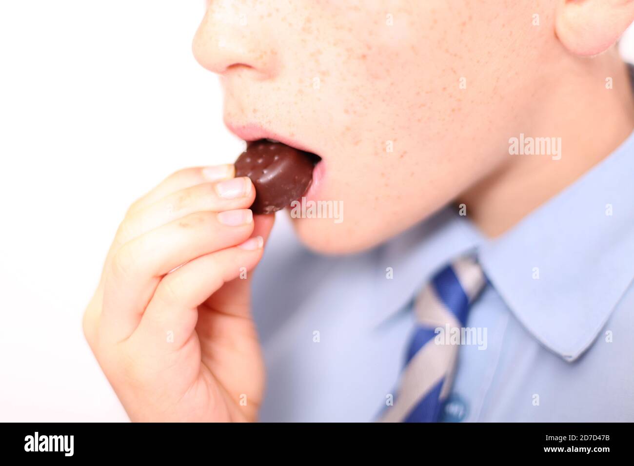 Bambino che mangia Quality Street Strawberry delizia cioccolato dolce, primo piano Foto Stock