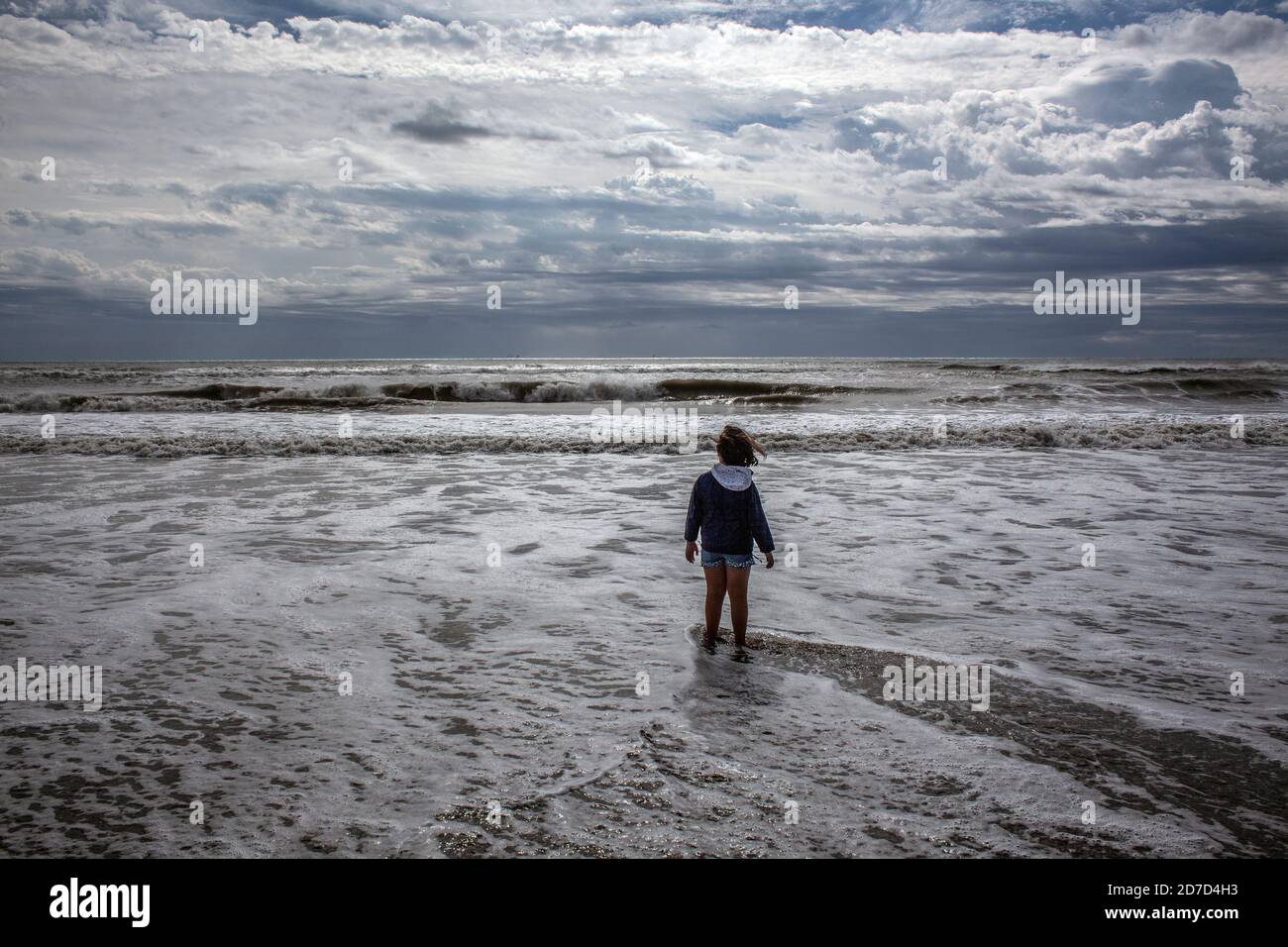 Solitario bambino in mare durante una giornata di tempesta. Foto Stock