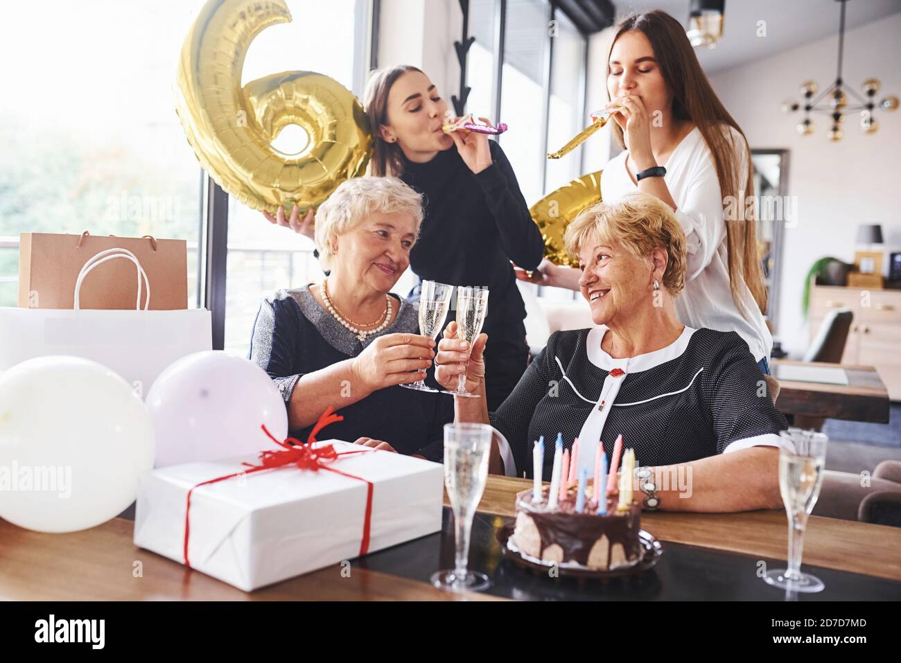 Palloncini con numero 60. Donna anziana con la famiglia e gli amici che  festeggiano un compleanno all'interno Foto stock - Alamy