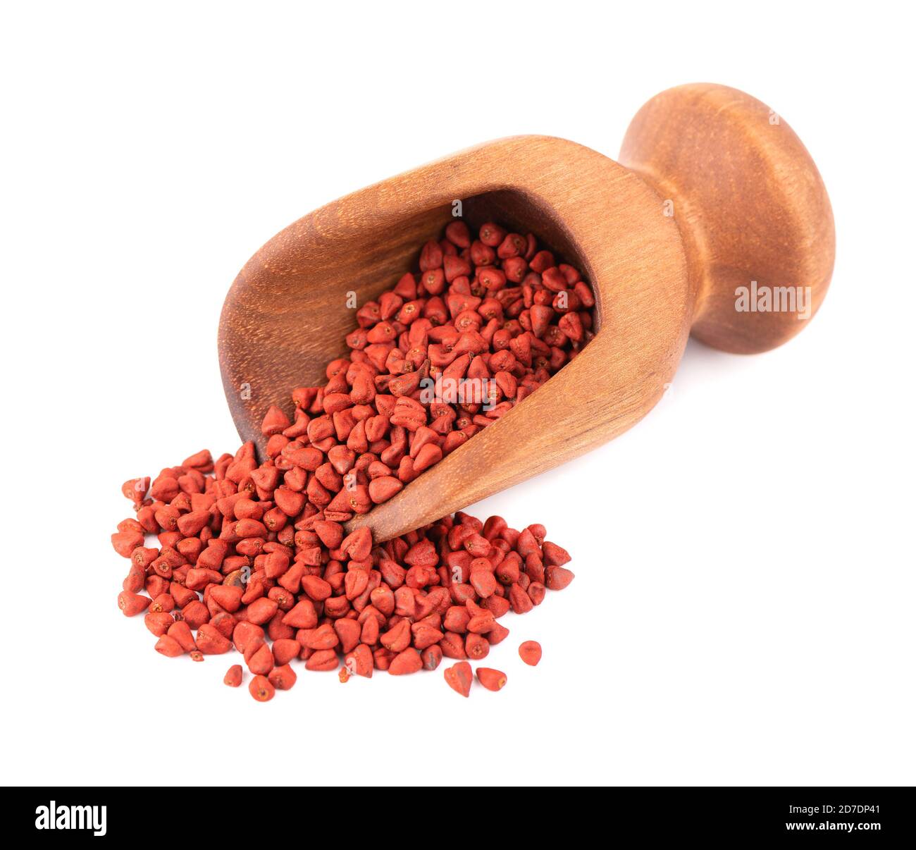 Semi di annatto in paletta di legno, isolati su sfondo bianco. Semi di Achiote, bixa orellana. Colorante naturale per la cottura e il cibo. Primo piano. Foto Stock