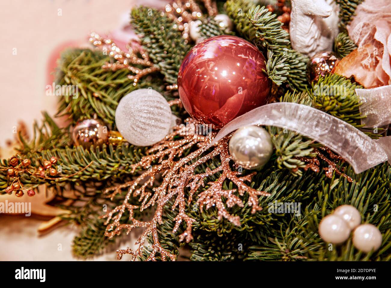 Composizioni e decorazioni natalizie realizzate in rami di abete, giocattoli, palline e fiori in fiera. Foto Stock