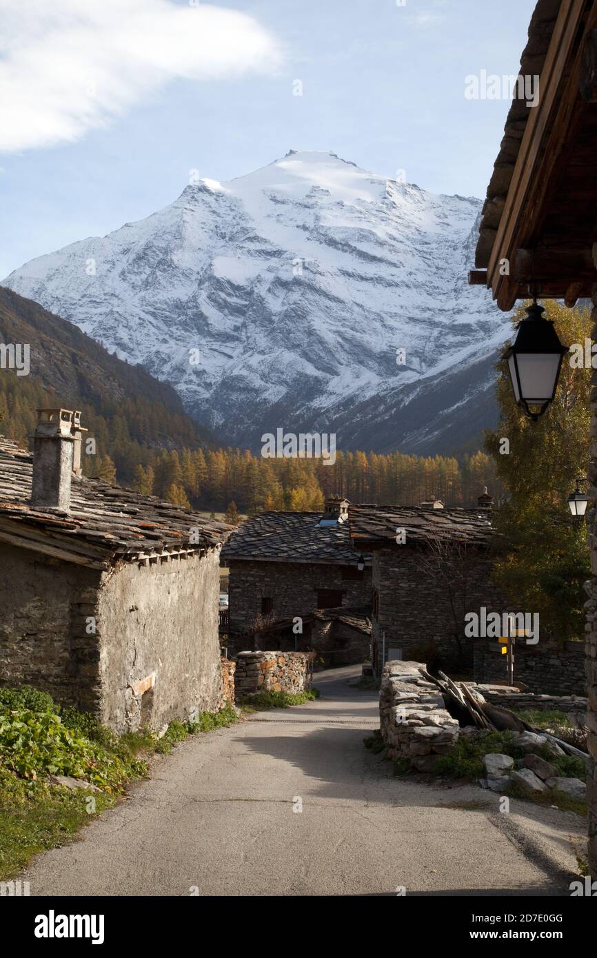 Paesaggio : le Villaron villaggio con case in pietra tradizionale, camino e lampione, montagna innevata sullo sfondo Pointe de Charbonnel Foto Stock