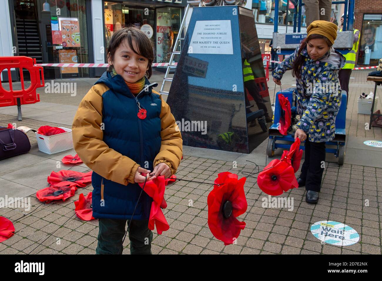 Windsor, Berkshire, Regno Unito. 22 ottobre 2020. Una nuova installazione di Poppy Fountain of Hope è stata installata oggi dal Windsor Yards Shopping Centre in collaborazione con la società di beneficenza BUSY Buttons DI Windsor. E' stato attaccato alla statua del Giubileo dei Diamanti delle sfere. Gli splendidi papaveri rossi sono stati fatti dai bambini dei servizi armati e dalle famiglie con materiale da paracadute rosse per raccogliere fondi per il giorno della memoria della Legione Britannica reale. Louella Fernandez-Lempiainen e il suo figlio Leon, di 10 anni, erano a disposizione, così come i membri delle guardie gallesi con sede a Windsor. Credit: Maureen McLean/Alamy Live News Foto Stock