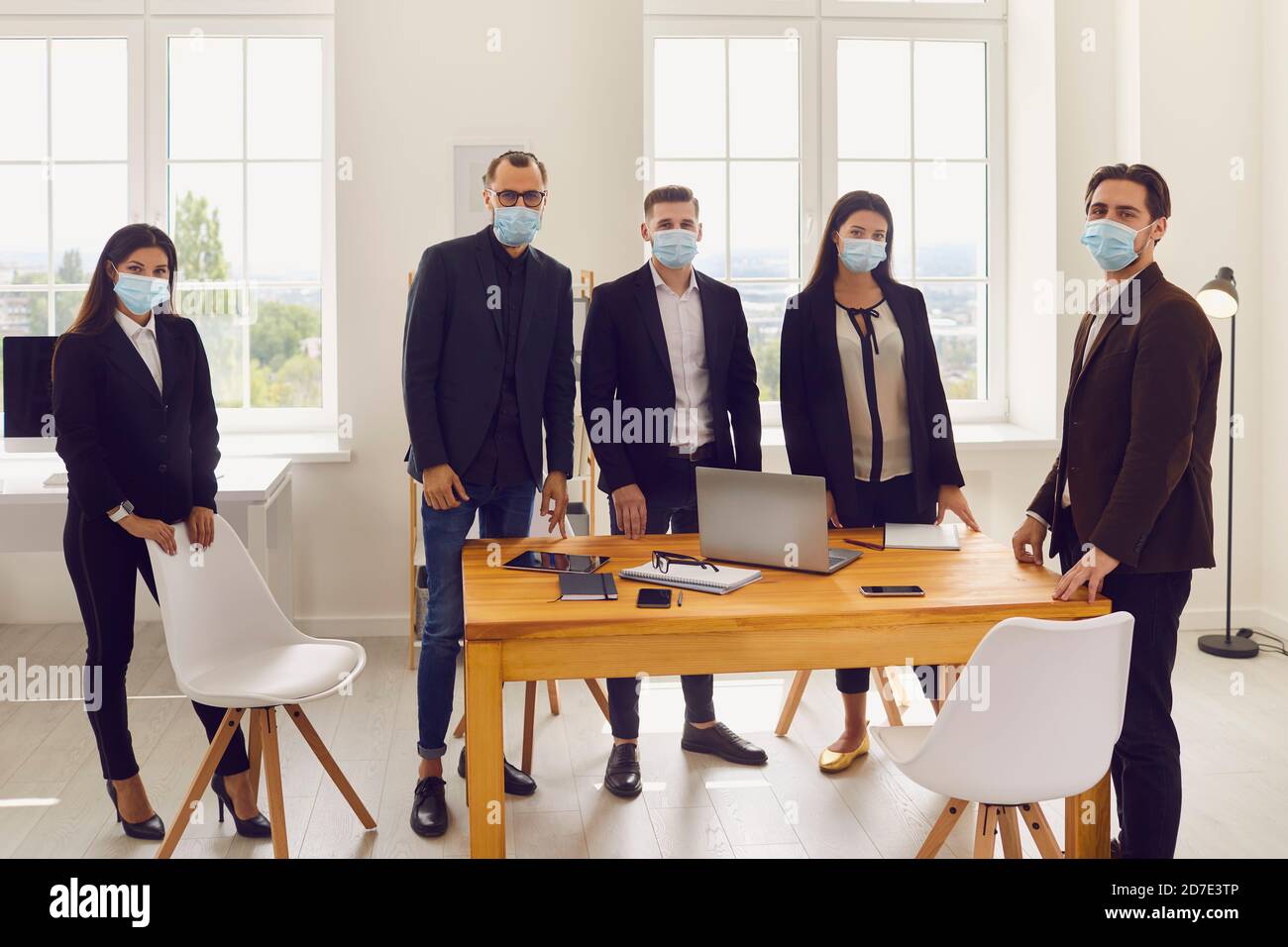 Gli impiegati indossano maschere facciali per proteggere i propri clienti e prevenire la diffusione di COVID-19. Foto Stock