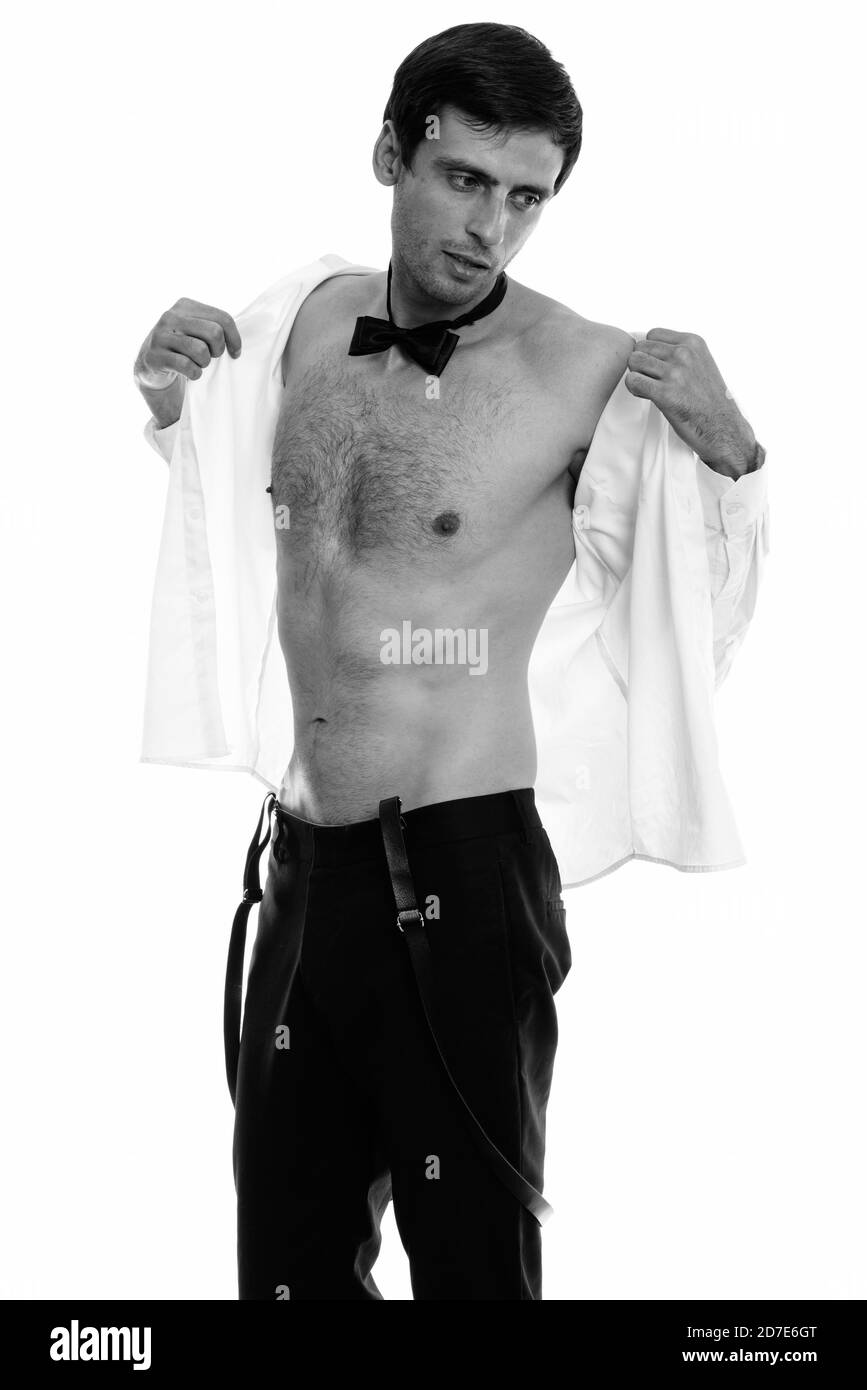 Studio shot del giovane uomo bello maglietta di apertura e di pensare mentre si indossa il filtro bow tie Foto Stock