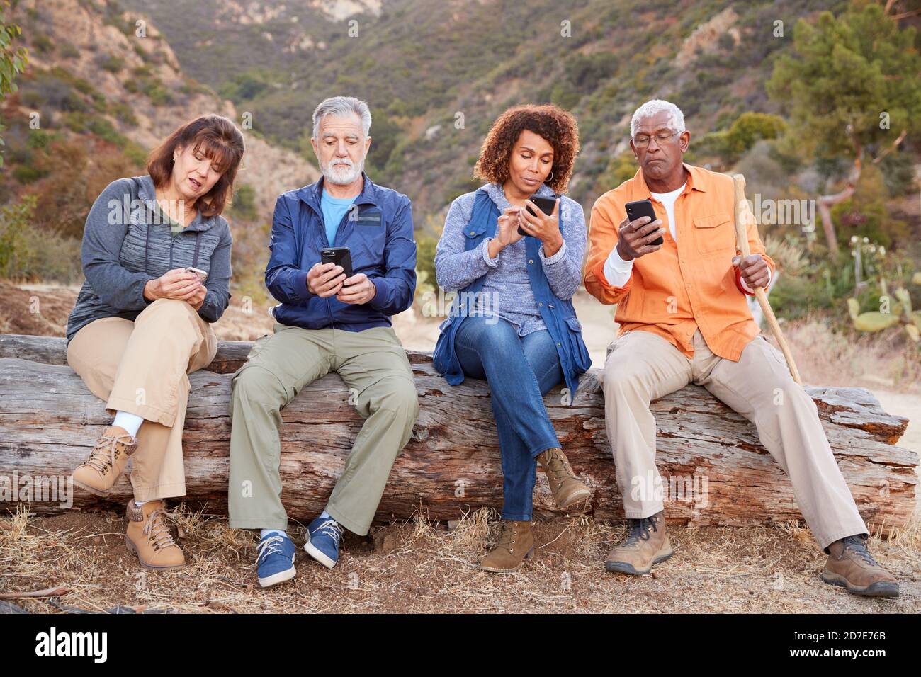 Gruppo di amici anziani in escursione in campagna controllare cellulari Telefoni per paura di perdere fuori Foto Stock