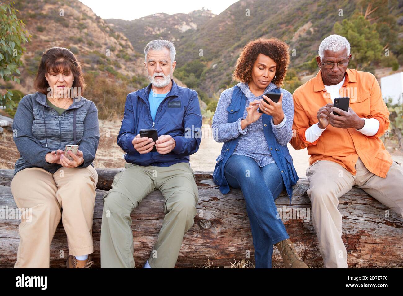 Gruppo di amici anziani in escursione in campagna controllare cellulari Telefoni per paura di perdere fuori Foto Stock