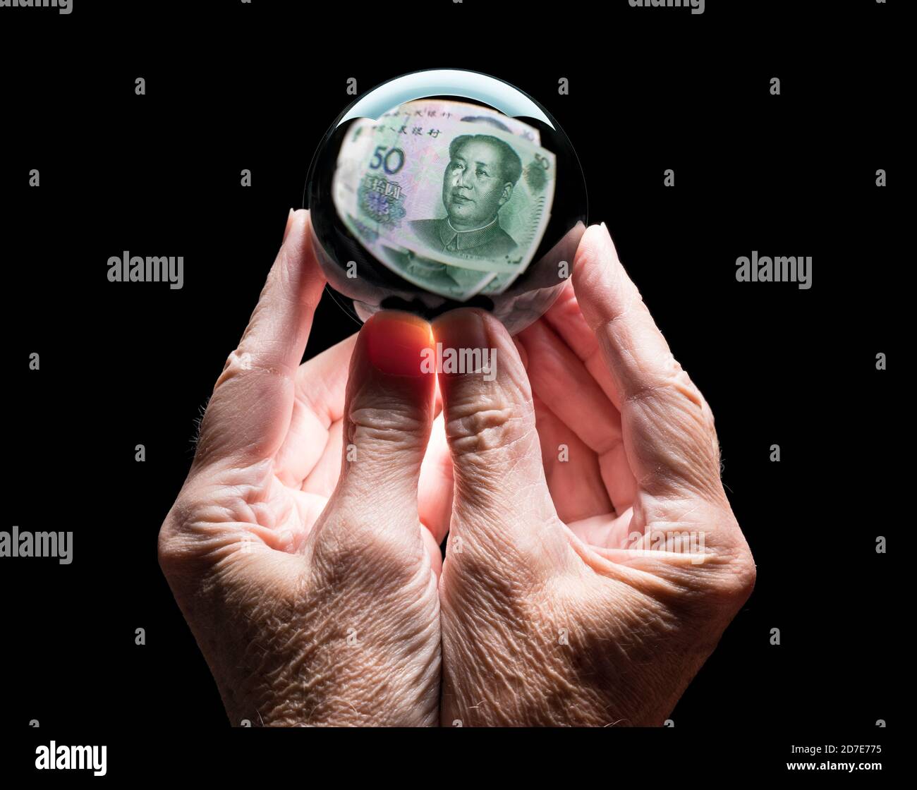 Mani caucasiche senior che tengono un cristallo futures o una palla di fortuna Riflettendo una nota di Yuan Cina 50 come concetto per il tasso di cambio per la valuta Foto Stock