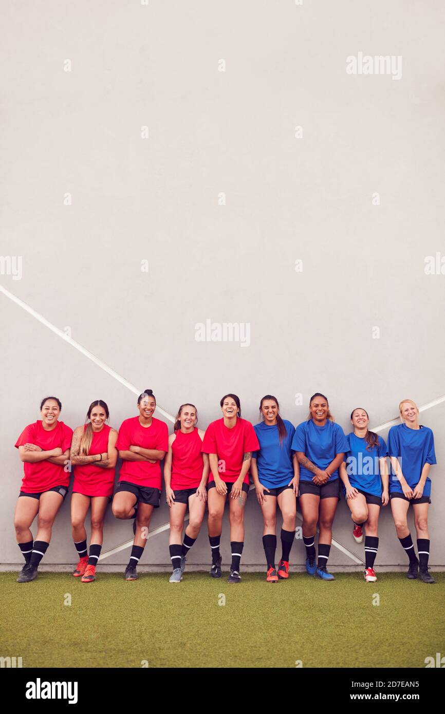 Immagine della squadra di calcio femminile che pende contro il muro mentre Allenamento per la partita di calcio Foto Stock