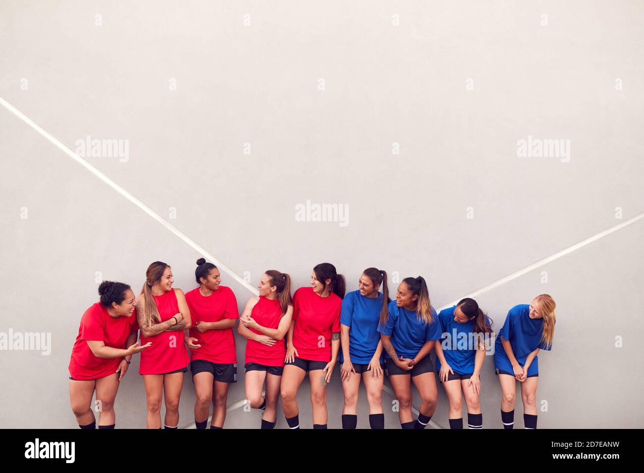 Immagine della squadra di calcio femminile che pende contro il muro mentre Allenamento per la partita di calcio Foto Stock