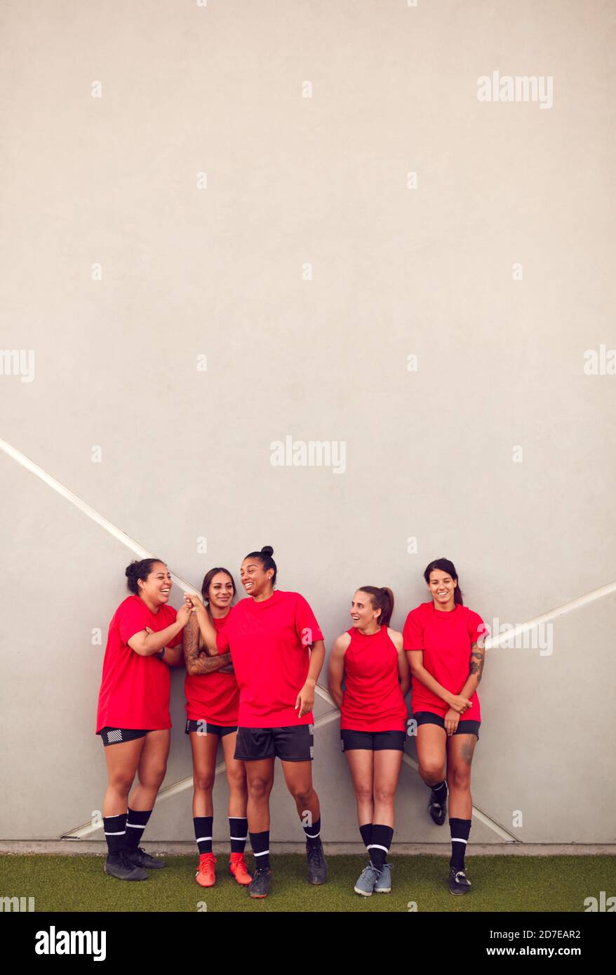 Immagine della squadra di calcio femminile che pende contro il muro mentre Allenamento per la partita di calcio Foto Stock