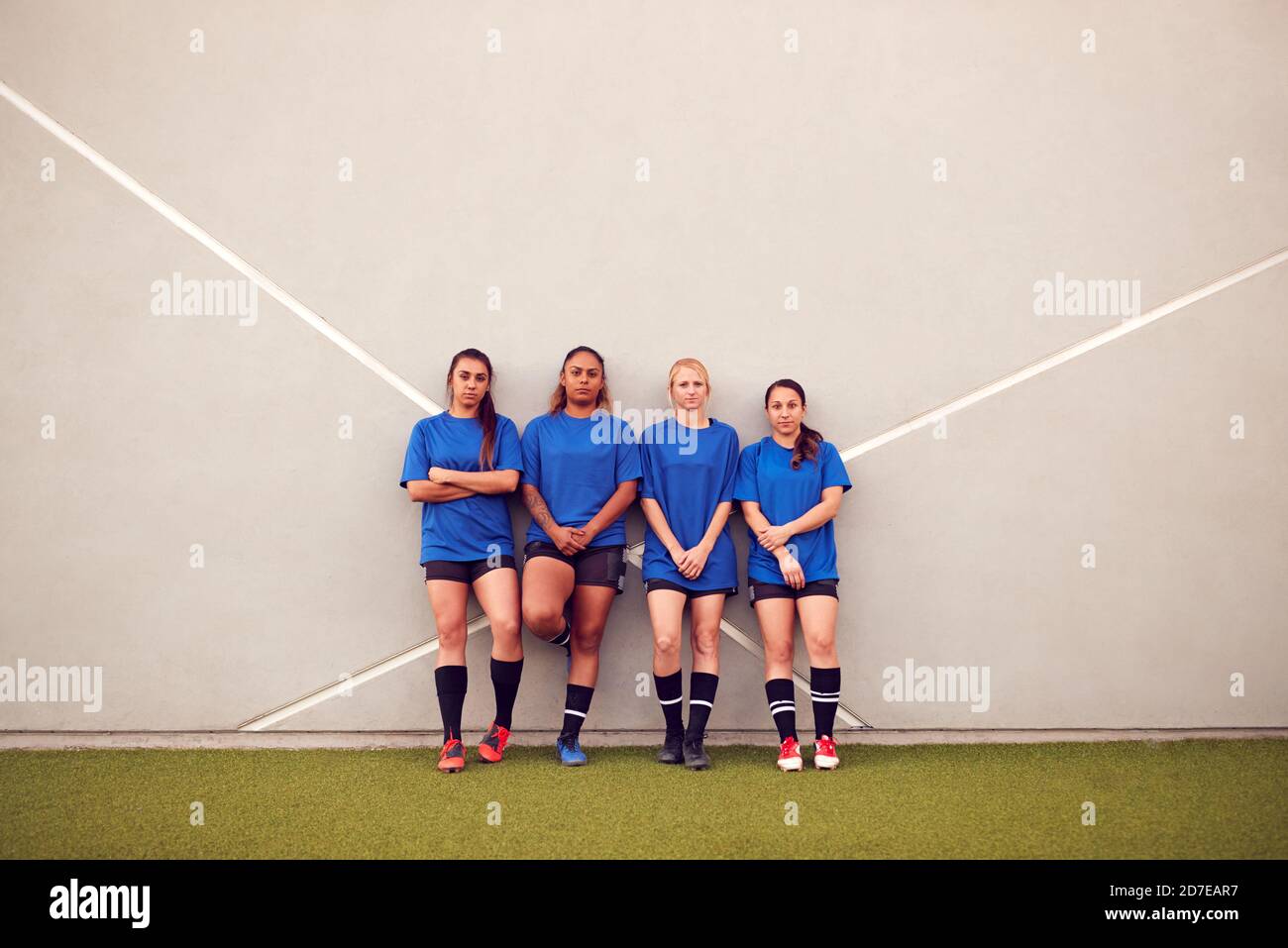 Immagine della squadra di calcio femminile che pende contro il muro mentre Allenamento per la partita di calcio Foto Stock