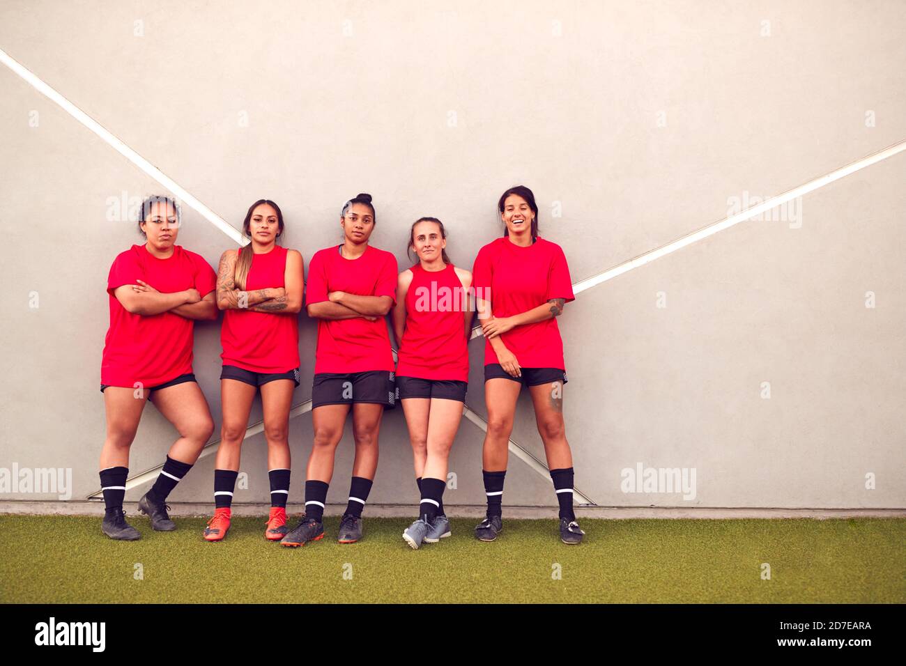 Immagine della squadra di calcio femminile che pende contro il muro mentre Allenamento per la partita di calcio Foto Stock