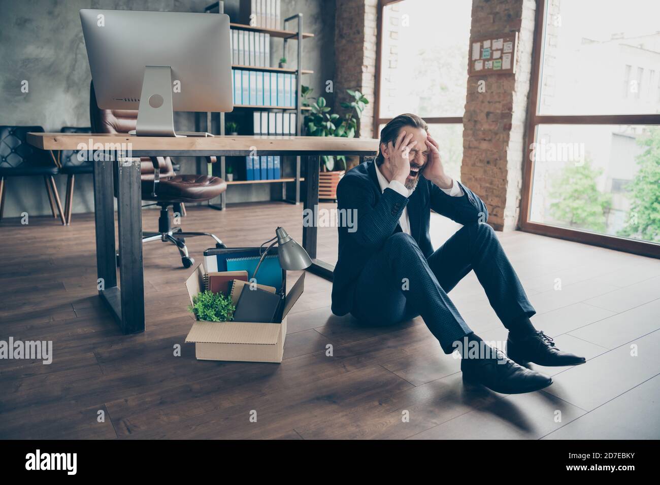 Foto di licenziato dismesso triste lavoratore maturo ragazzo guasto infornato agente perso lavoro impacchettato oggetti di crisi finanziaria sit pavimento in parquet senza speranza Foto Stock