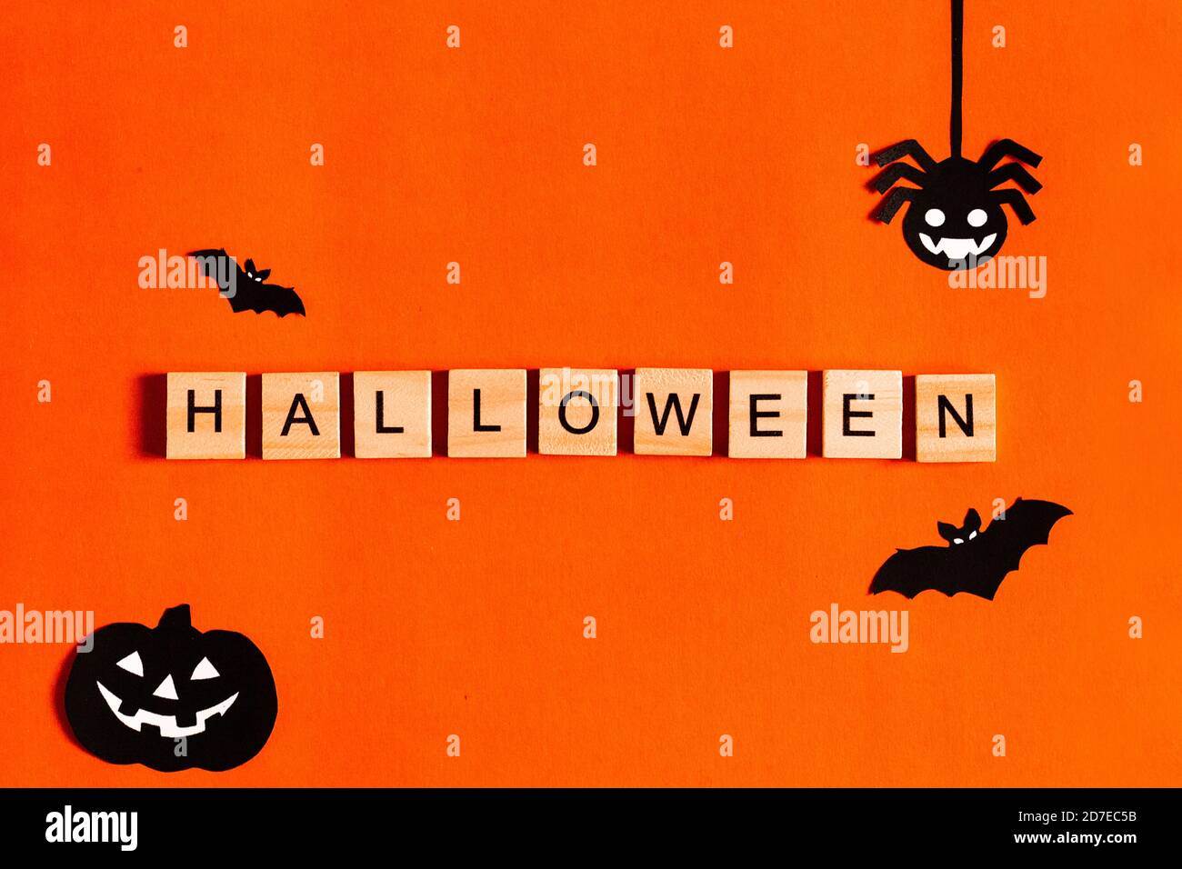 Scritta Halloween su sfondo arancione con silhouette di carta nera, pipistrelli, zucca, ragno. Il concetto di Halloween. La vista dall'alto Foto Stock