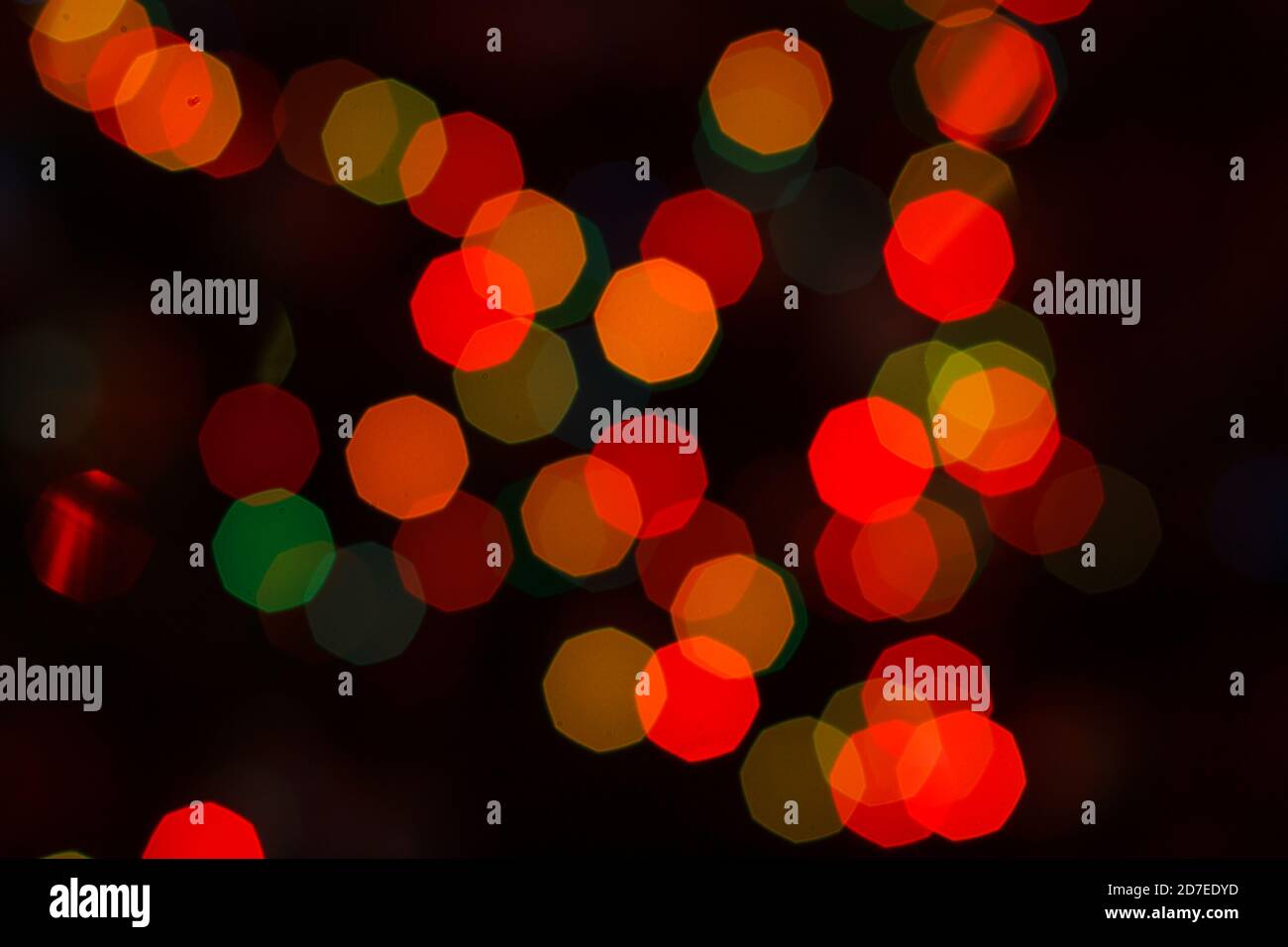 Sfondo sfocato con colorate luci rosse festive. Sfondo bokeh circolare astratto. Foto Stock