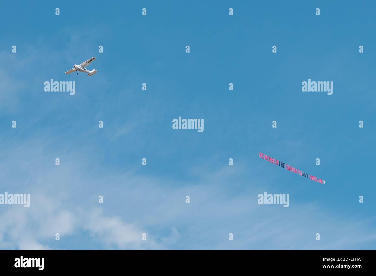 Piccolo piano Cessna skywriting, tirando standard lettera banner 'membro il giorno del Sabbath' messaggio cristiano Foto Stock