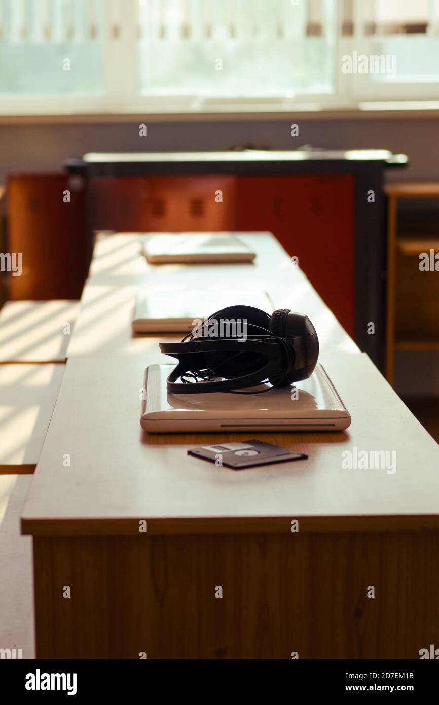 Le cuffie e i computer portatili sono sdraiati sulle scrivanie Foto Stock