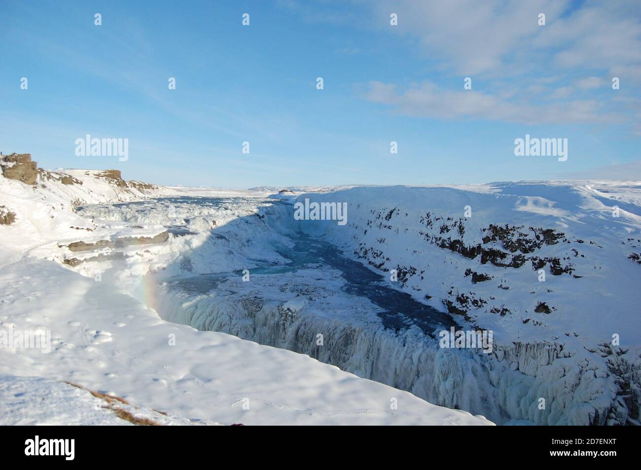 Cascata Gullfoss vista panoramica in Islanda in inverno coperto da neve e arcobaleno e cielo blu chiaro sopra Foto Stock