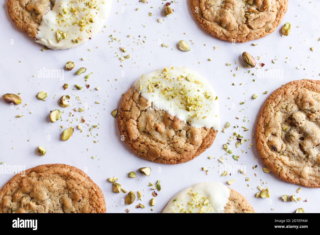 Vista orizzontale dall'alto dei biscotti al pistacchio e al cioccolato bianco su un piano in marmo bianco. Foto Stock