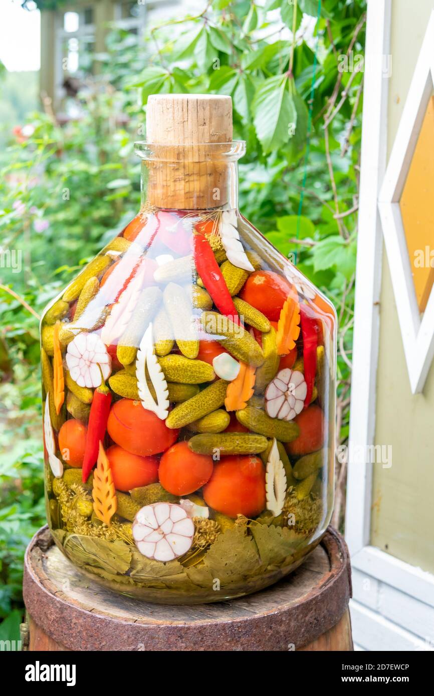 Bottiglia di vetro con pomodori marinati e cetrioli al barile Foto Stock