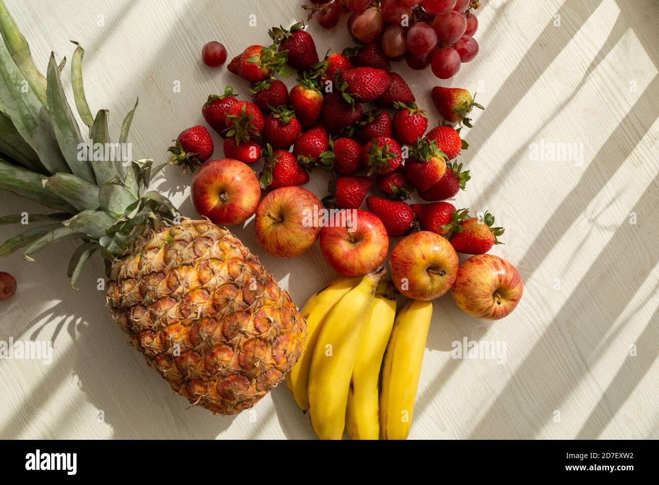 deliziosa frutta fresca con ombra , ananas, banane, mela, fragola, uva e banane, sono in raws, sano stile di vita, studio Foto Stock
