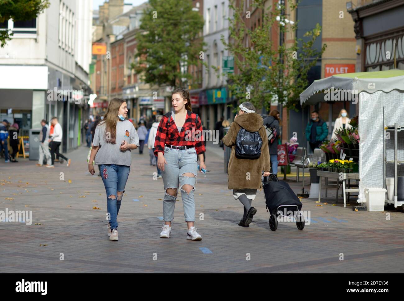 Due giovani donne, con jeans strappati, camminando a Nottingham Foto Stock