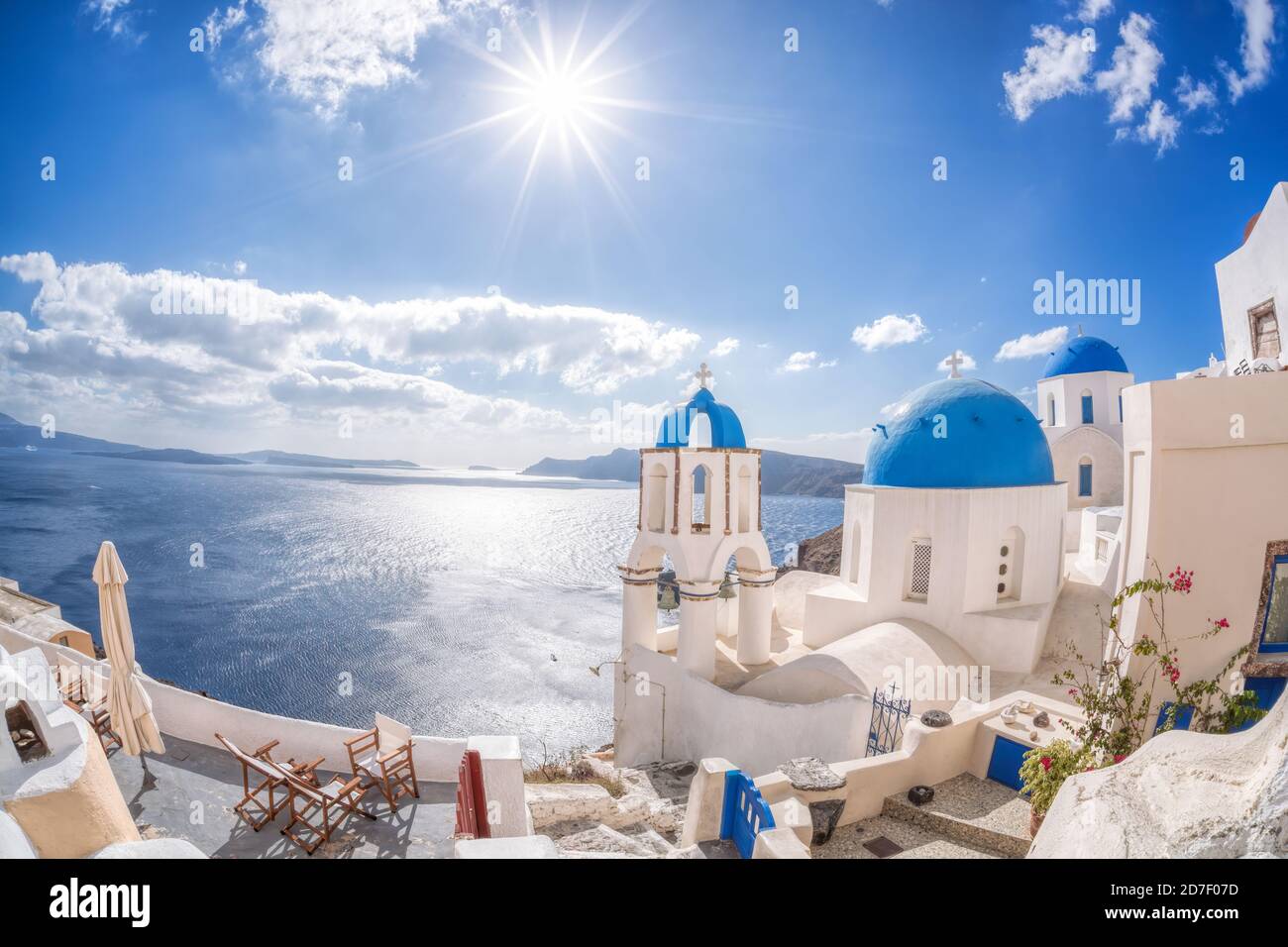 Oia villaggio con chiese contro mare azzurro sull'isola di Santorini In Grecia Foto Stock