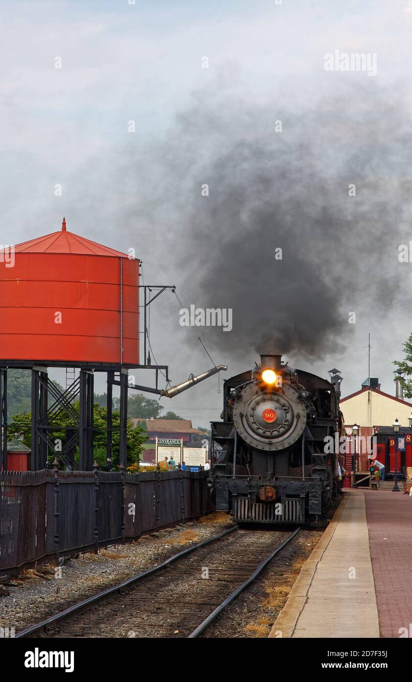 Treno a vapore antico, in arrivo alla stazione, serbatoio d'acqua rosso, nube di vapore nero, giro turistico, locomotiva n. 90, trasporto, Strasburg Railroad, Lancast Foto Stock