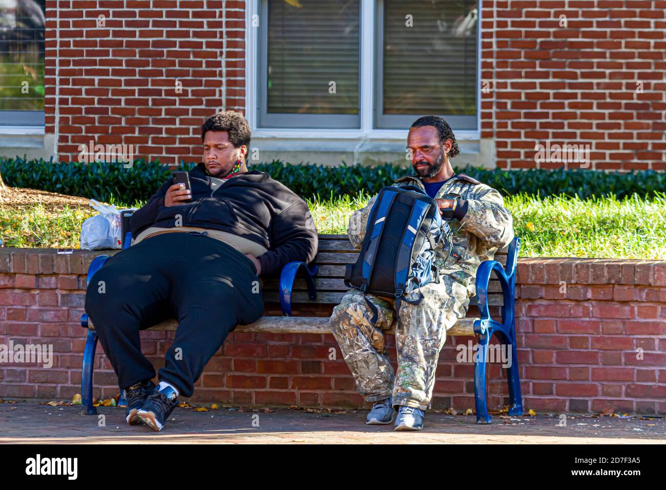 Frederick, MD 10/13/2020: Due uomini afroamericani che vivono per le strade sono seduti su una panchina in un parco a Frederick, Maryland. I senzatetto hanno anziani Foto Stock