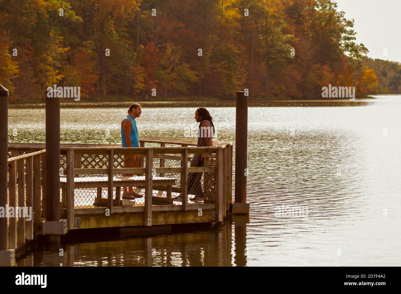 Boyds, MD, USA 10/20/2020: Un giovane afroamericano e il suo amico caucasico stanno facendo una discussione accesa mentre si trovano sul molo di legno da li Foto Stock
