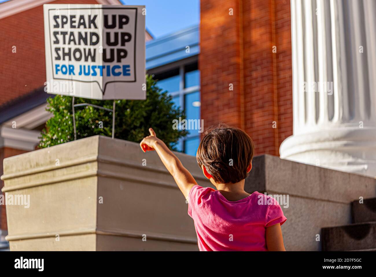 Un'immagine astratta unica in cui una bambina sta indicando un posto di segno che dice parlare in su, levarsi in piedi in su, mostrare in su per giustizia. Un'immagine concettuale per i social awar Foto Stock