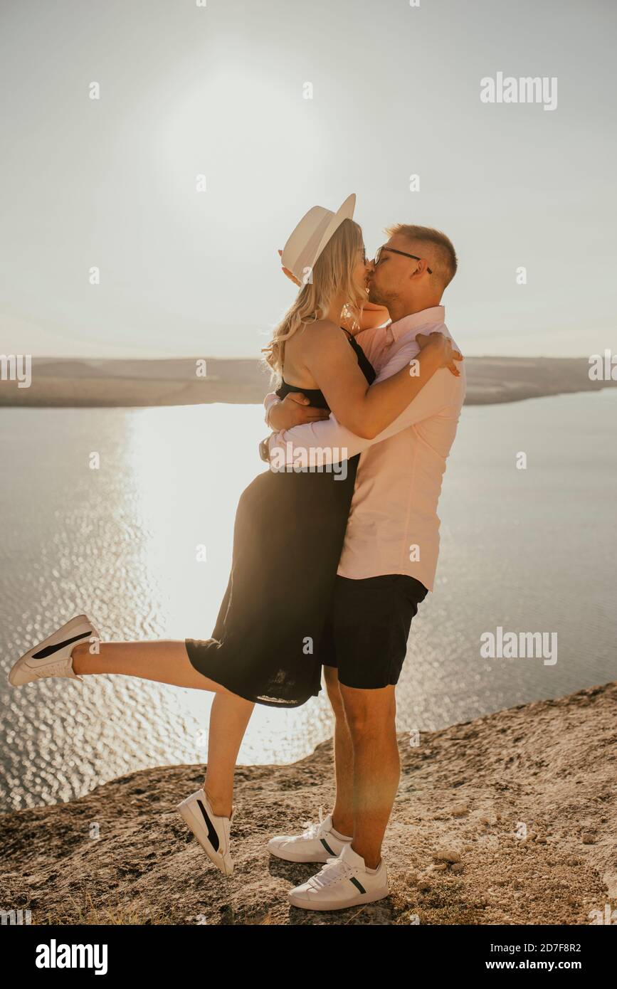 l'uomo e la donna in cappello camminano lungo le rocce sopra il scogliera Foto Stock