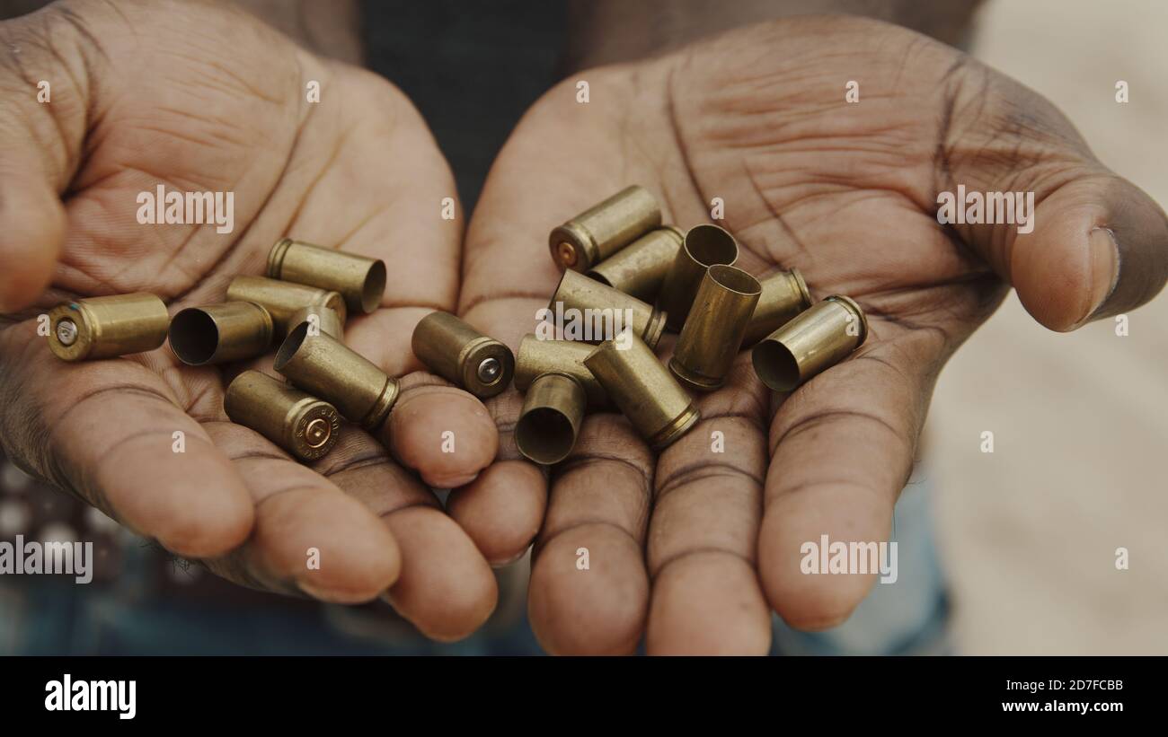 Primo piano, uomo africano che tiene in mano i casi di bulet. Foto di alta qualità Foto Stock