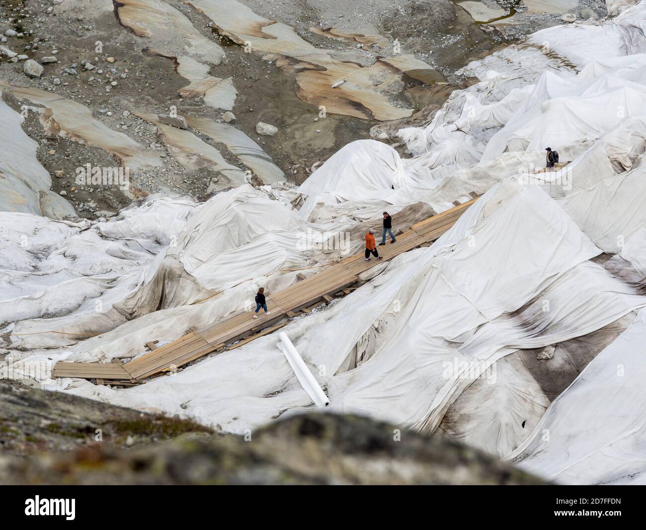 Si cammina fino all'ingresso della grotta di ghiaccio, ghiacciaio del Rodano coperto di fogli per proteggere il ghiaccio dal fondersi sopra la grotta del ghiacciaio, Belvedere, Svizzera Foto Stock