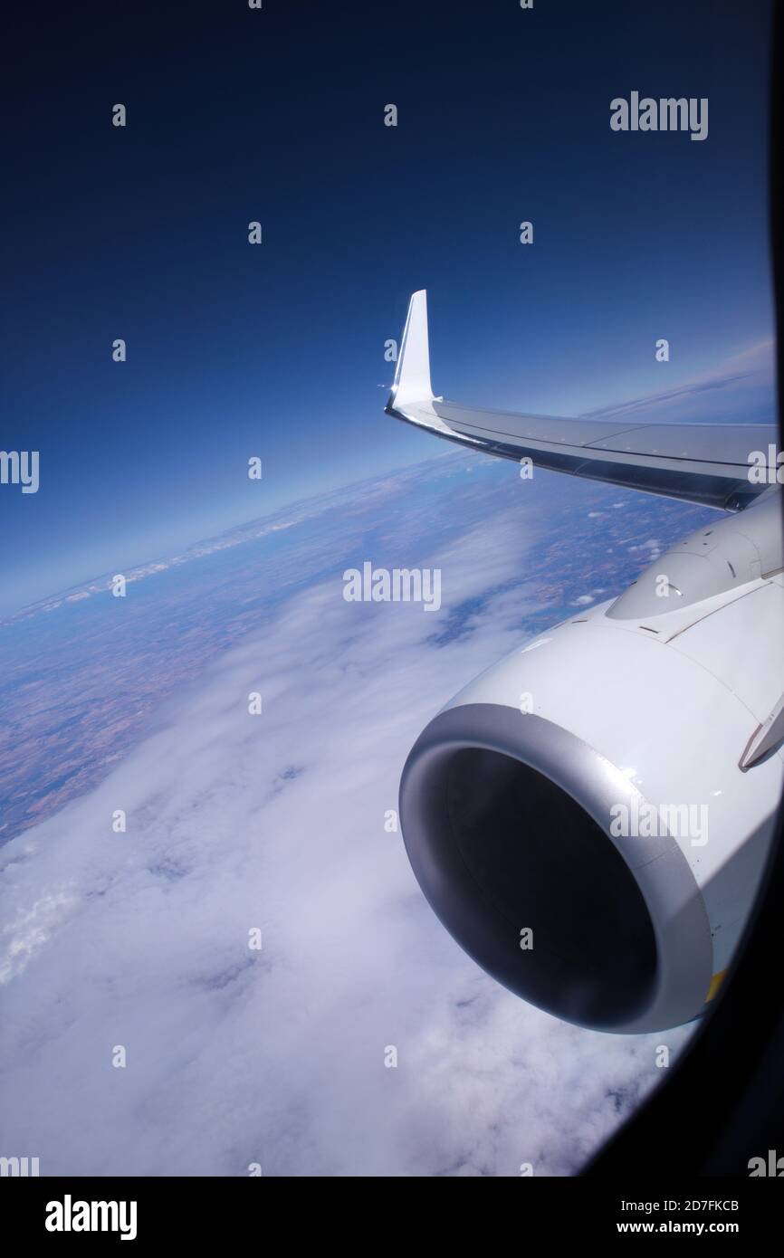 Immagine dalla finestra di un aereo commerciale in cui si può vedere uno dei motori e parte dell'ala, sullo sfondo si possono vedere le nuvole Foto Stock
