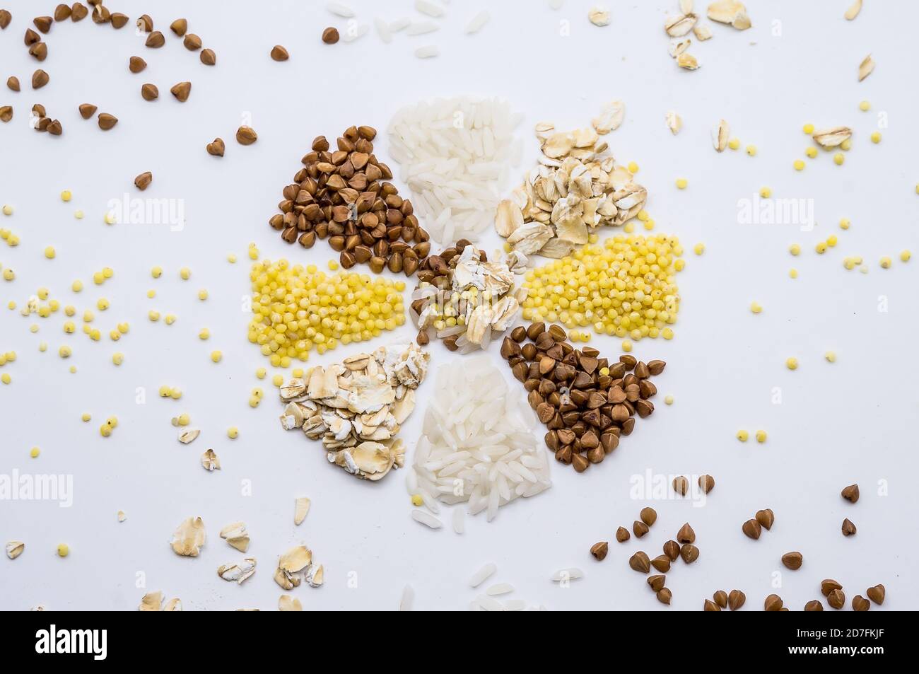 porridge a grani multipli, riso di farina d'avena e grano saraceno su fondo bianco, fiocco di neve da grani, fiore da cereali Foto Stock