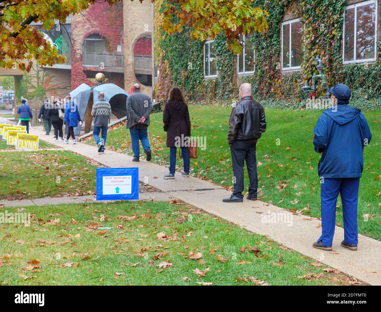 Oak Park, Illinois, Stati Uniti. 22 ottobre 2020. I primi elettori sopportano il clima umido e aspettano fino ad un'ora e mezza per votare oggi nella sala del villaggio in questo sobborgo occidentale di Chicago. Foto Stock