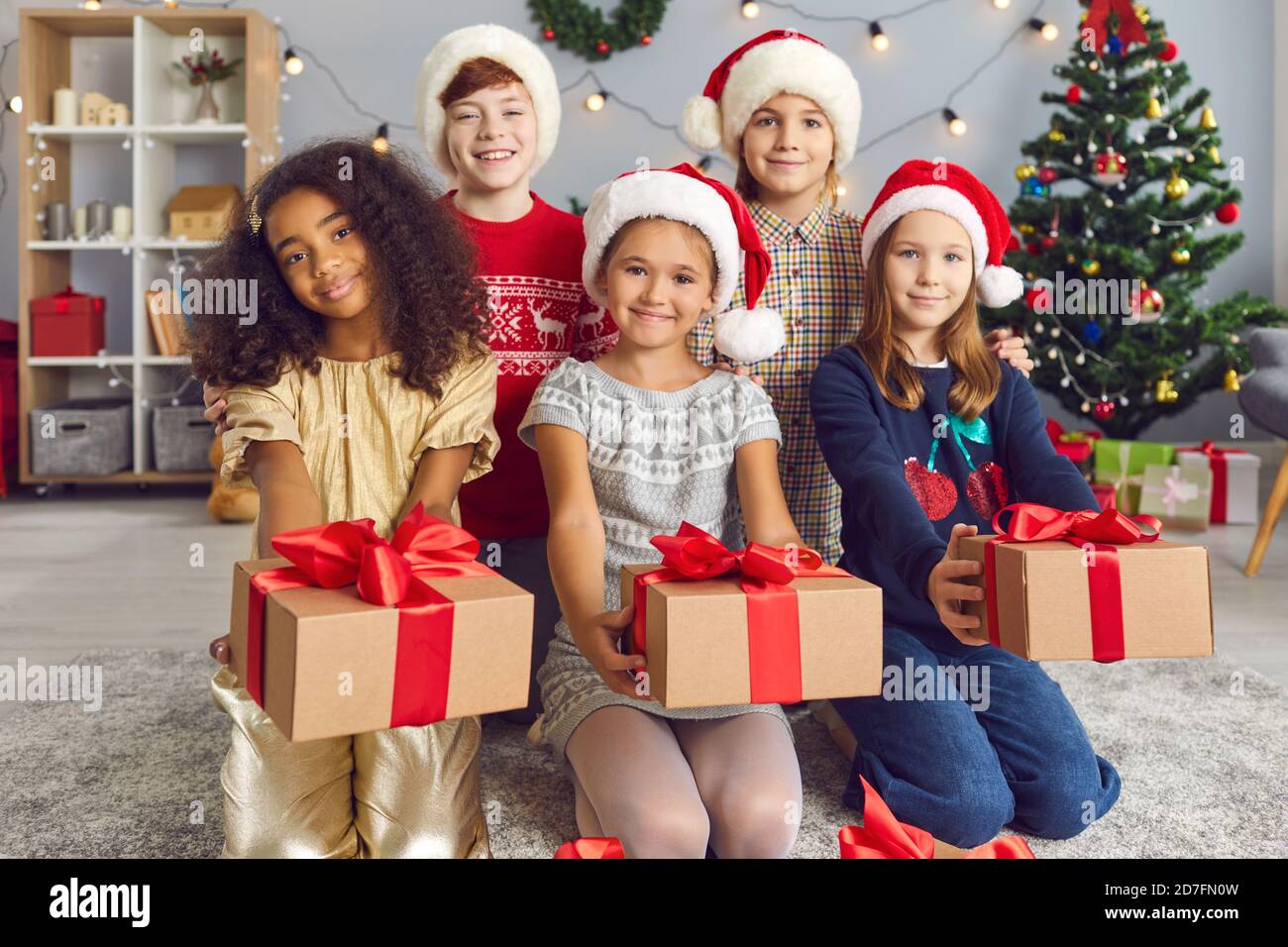 Gruppo di felici bambini multirazziali che tengono i regali di Natale che hanno preparato per gli amici Foto Stock