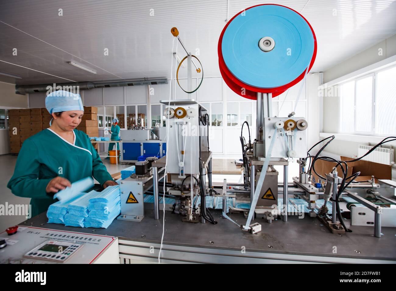 Taraz/Kazakhstan-Aprile 25 2012: Impianto medico Superfarm. Produzione di forniture mediche. Linea di produzione maschera facciale. Operatore professionale di macchine da cucire. Foto Stock