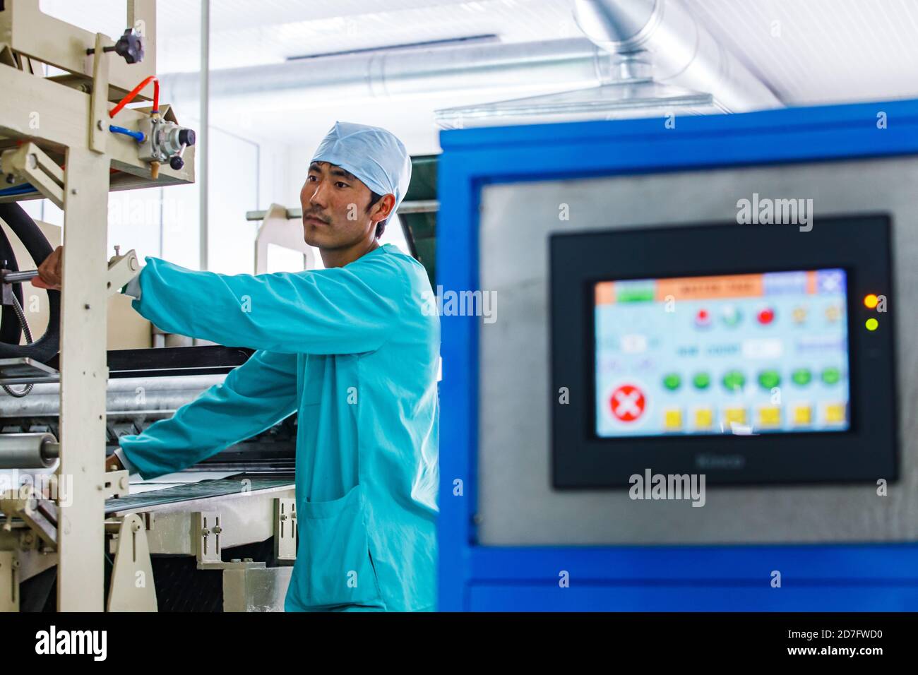 Taraz/Kazakhstan - Aprile 25 2012: Impianto medico Superfarm. Produzione di forniture mediche. Linea di produzione e giovane operatore asiatico. Foto Stock