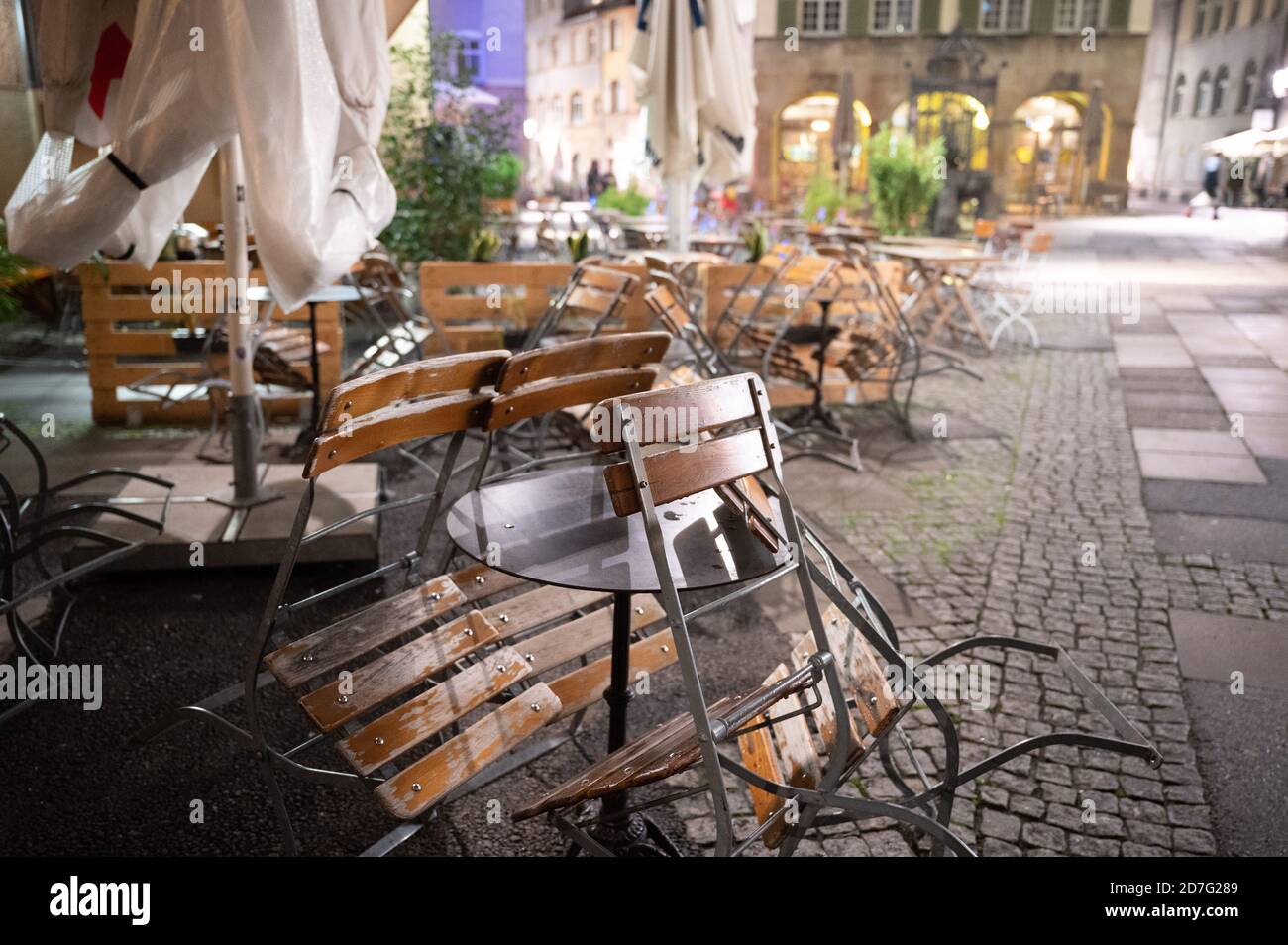 Stoccarda, Germania. 22 ottobre 2020. Le sedie nell'area esterna di un ristorante si trovano all'Hans-im-Glück-Brunnen mezz'ora dopo l'orario di chiusura della corona. A causa degli alti numeri di corona, la capitale dello stato del Baden-Württemberg ha vietato la gestione dei ristoranti tra le 11 e le 6 dal giovedì. Credit: Sebastian Gollnow/dpa/Alamy Live News Foto Stock