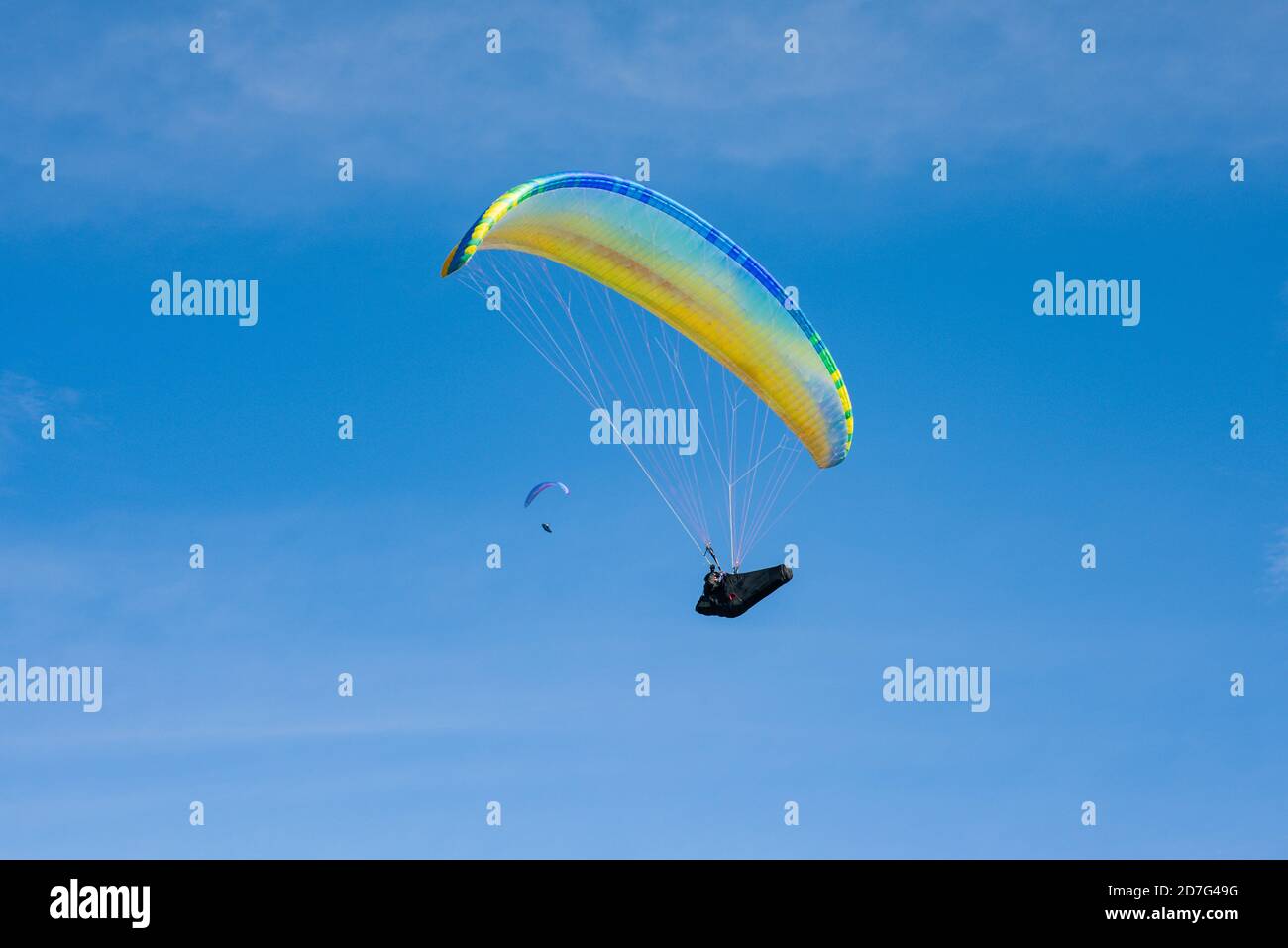 Parapendio colorato su uno sfondo blu cielo. Sport estremo. Folle hobby. Foto Stock