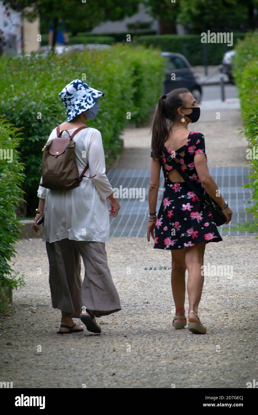 Due donne che indossano maschere passeggiano per la città di Arezzo Foto Stock