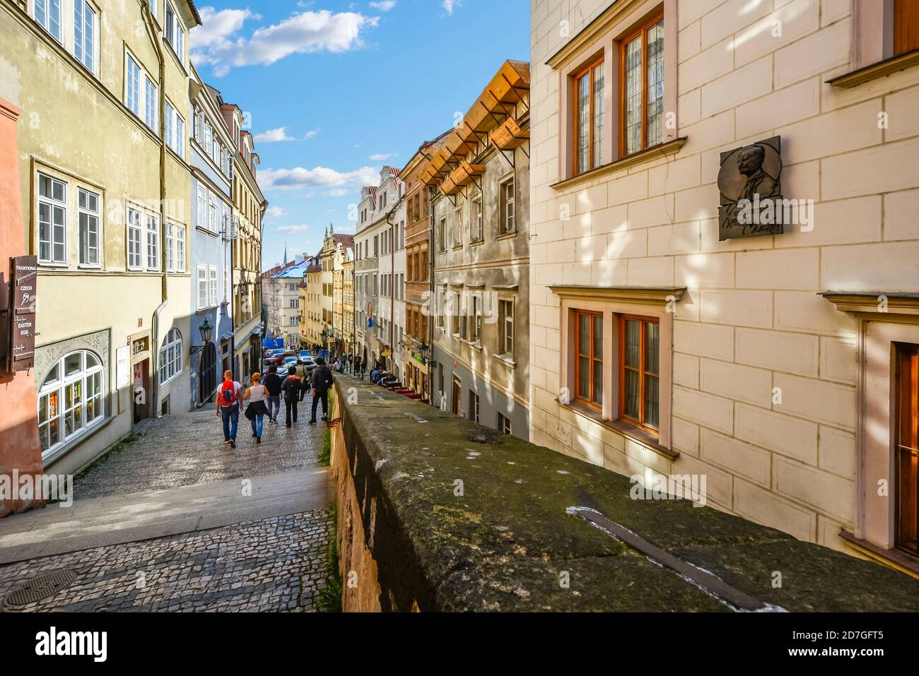I turisti si dirigono lungo la lunga scalinata attraverso un quartiere residenziale dal Castello di Praga attraverso la Città bassa verso la Città Vecchia di Praga, in Czechia Foto Stock