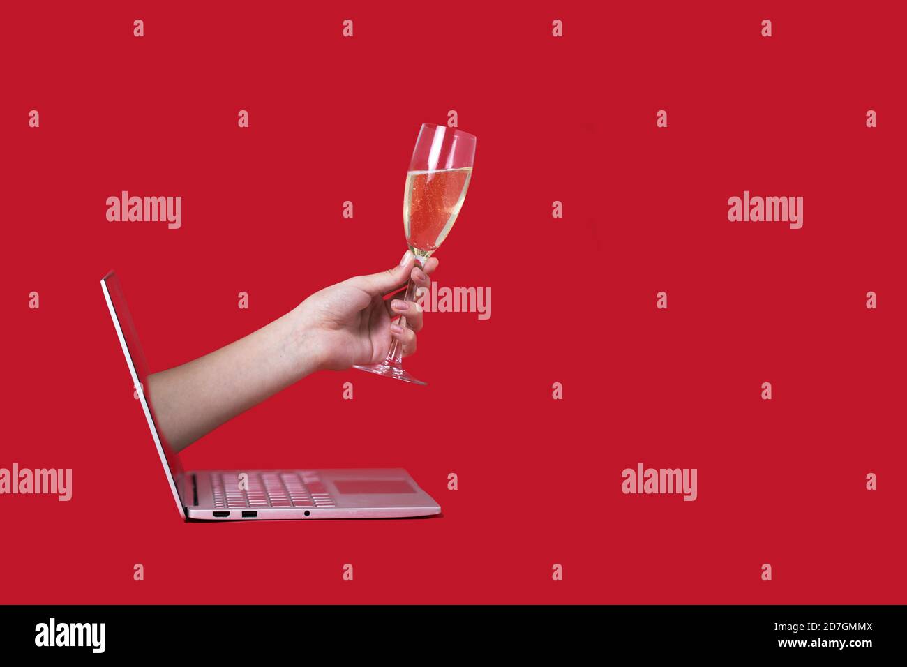 Regalando un bicchiere di champagne dallo schermo del computer online sfondo rosso celebrazione natale capodanno di festa Foto Stock