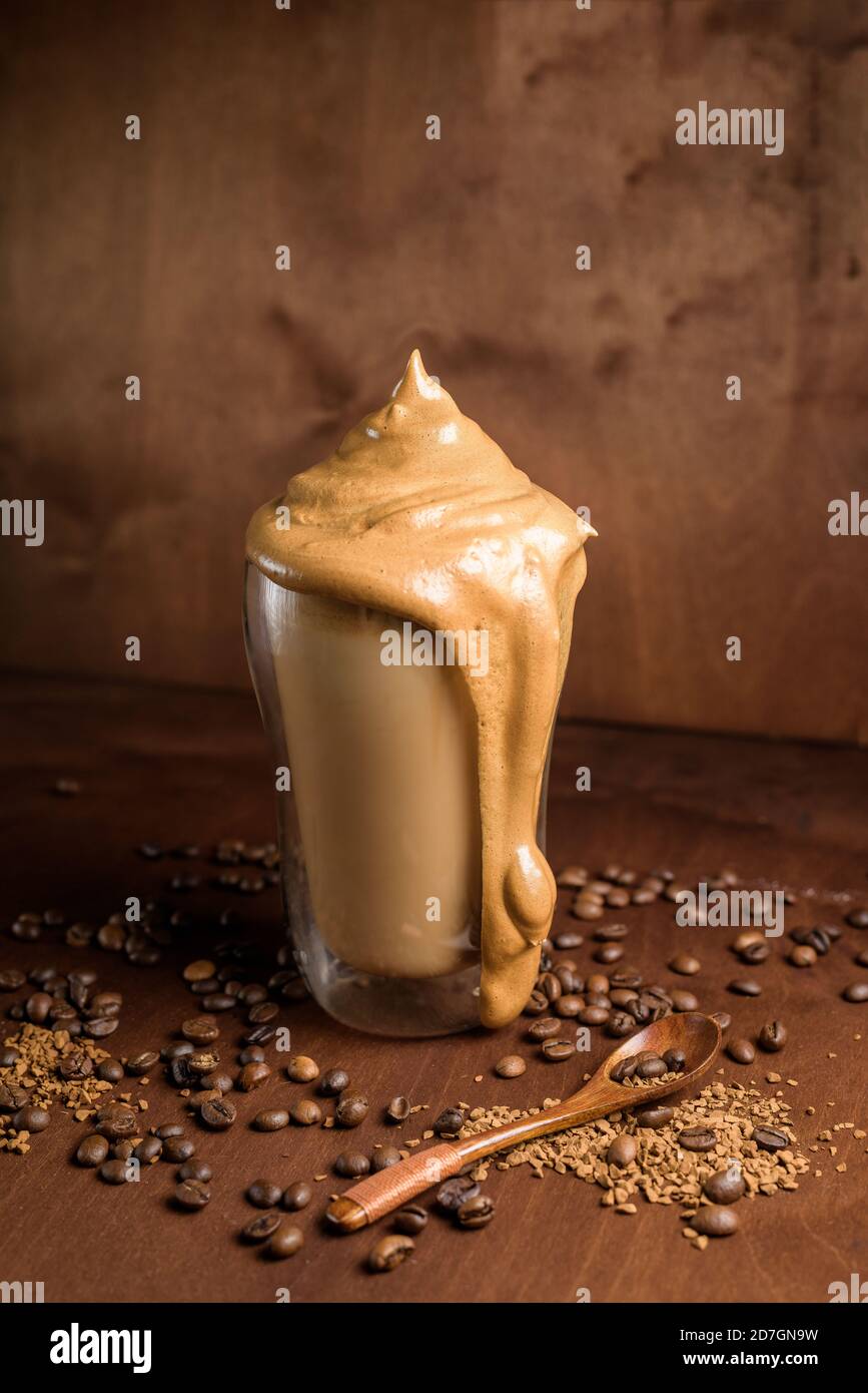 caffè di algone freddo in bicchieri trasparenti su fondo di legno scuro. schiuma di zucchero e caffè istantaneo viene montata con un miscelatore sul latte freddo. Coreano e. Foto Stock