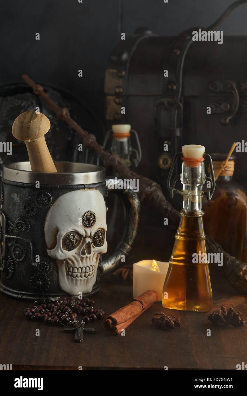 Pozioni magiche in bottiglie, bare e bacchetta magica su sfondo di legno scuro Foto Stock