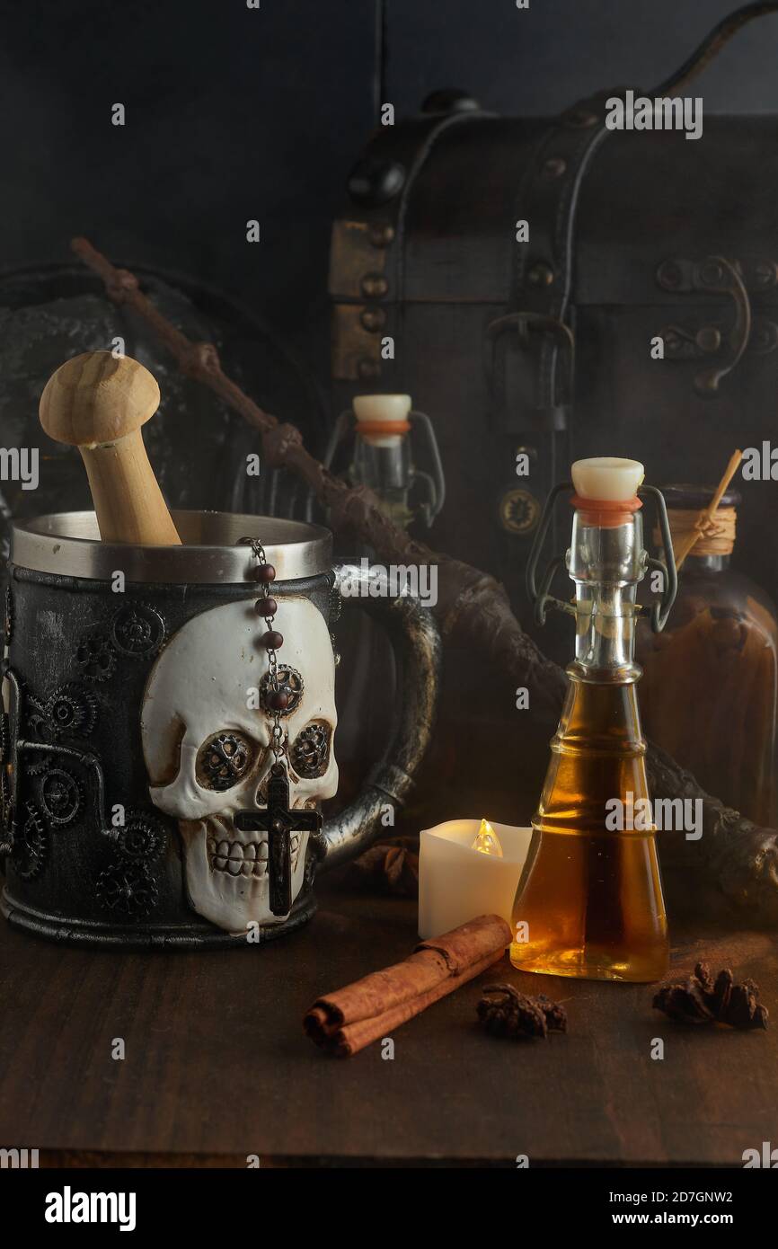 Pozioni magiche in bottiglie, bare e bacchetta magica su sfondo di legno scuro Foto Stock